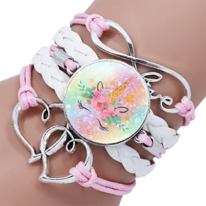 Macro detail of a multilayer unicorn cabochon bracelet with pink and white braided cords
