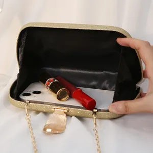 Gold glitter evening box clutch with metal leaf clasp showing spacious interior capacity