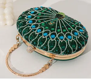 Detailansicht der eleganten Pfauen-Abendtasche mit smaragdgrünen Strasssteinen und Kette.