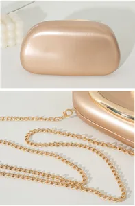 Detailansicht einer champagnergoldenen Abendtasche mit einer eleganten Metallkette