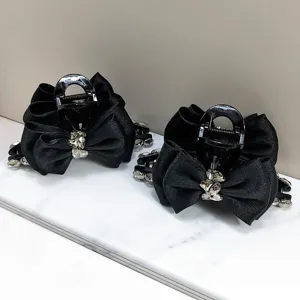 Detailopname van elegante zwarte satijnen strik haarklemmen met K9-kristalaccenten