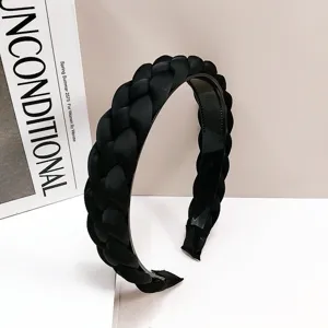 Serre-tête tressé noir élégant avec dents pour un effet de volume capillaire chic.