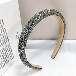 Detailansicht der silbernen Kristallverzierung auf einem luxuriösen grauen Stirnband