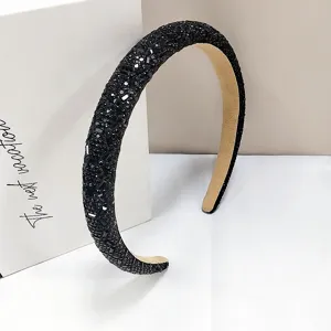Primer plano de una elegante diadema de pedrería negra brillante con acabado de lujo