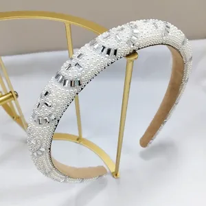 Detalle de diadema de lujo con perlas y cristales en soporte dorado.