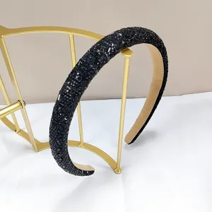 Primer plano de diadema negra elegante con lentejuelas en un soporte de metal dorado