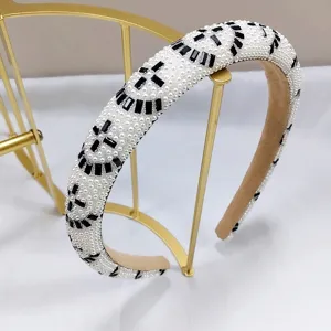 Detalle de diadema acolchada con perlas blancas y cristales negros para mujer