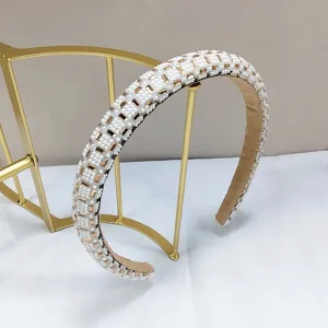 Detailweergave van een elegante haarband met parels en gouden strass-steentjes voor dames