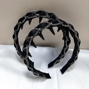 Detalle de diademas trenzadas negras con pedrería plateada y puntas de estilo gótico.