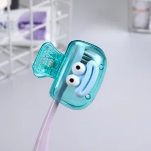 Close-up of a cute turquoise toothbrush clip with a cartoon face design
