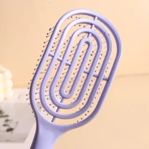 Macro view of purple vented hairbrush with oval hollow design for scalp massage