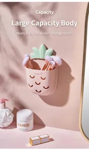 Close-up of pink pineapple-shaped wall-mounted storage box holding makeup brushes