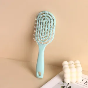 Mint green vented hairbrush for scalp massage and volumizing on a minimalist background