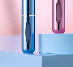 Primer plano de atomizadores de perfume recargables de 5 ml con un acabado metálico brillante.