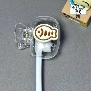 Close-up view of a transparent plastic toothbrush head cover with cute fish pattern