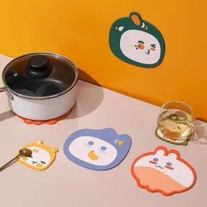 Close-up of cute cartoon animal silicone heat insulation pads used for pots and cups on a table