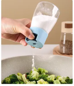 Close-up showing a quantitative salt shaker pouring exactly 0.5g salt onto fresh broccoli.