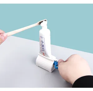 Close-up of a manual rolling toothpaste squeezer showing the efficient dispensing action