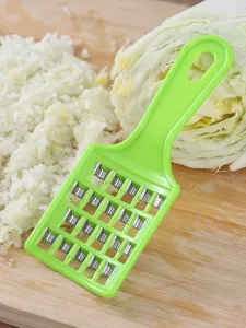 Picadora de col verde manual con cuchillas de metal sobre una tabla de cortar madera