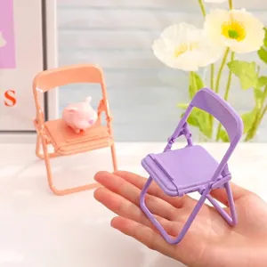 Portable mini folding chair phone stand in cute macaron colors held in a human palm