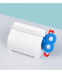 Detail view of manual plastic toothpaste squeezer with blue rotation handle