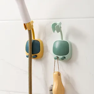 Close-up detail of two wall-mounted adjustable shower head holders with hooks on marble