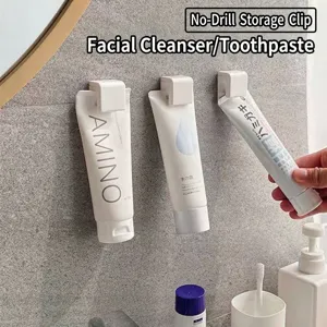 Minimalist wall-mounted punch-free storage clip for toothpaste and cleanser tubes