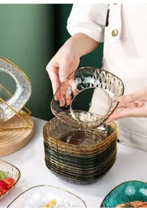 Primer plano de una persona sosteniendo un plato de aperitivos transparente facetado