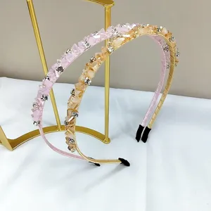 Close-up of handmade crystal and rhinestone headbands on a gold display stand
