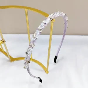 Detail of handmade purple crystal headband with sparkling rhinestones on gold stand