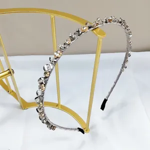 Handmade crystal beaded headband with shimmering rhinestones on a gold display stand