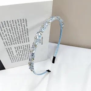 Detail shot of a handmade light blue headband with sparkling crystals and rhinestones.