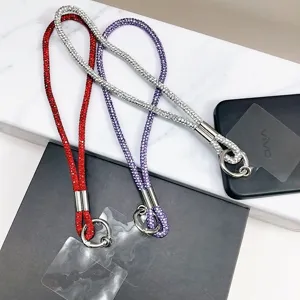 Vue détaillée de trois lanières de téléphone de luxe incrustées de strass en rouge, violet et argent