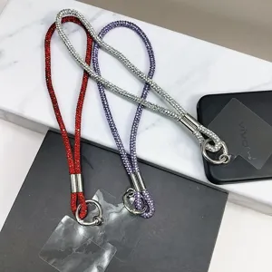 Vue détaillée de trois lanières scintillantes en strass rouge, violet et argenté