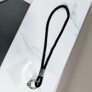 Gros plan du cordon de téléphone en strass noirs avec fermoir anneau argenté et insert
