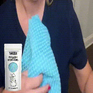 Close-up of TORVIKX blue exfoliating shower towel being used for body cleaning