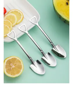 Close-up of three creative shovel-shaped stainless steel dessert spoons with fruit
