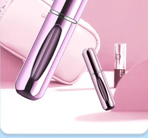 Primer plano de un atomizador de perfume de viaje recargable rosa metálico de 5 ml.