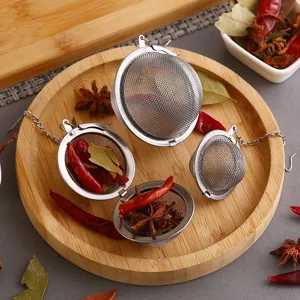 304 stainless steel mesh tea balls and spice strainers on a wooden tray with spices.