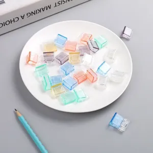 Macro shot of colorful transparent push clips for office paper and book binding.