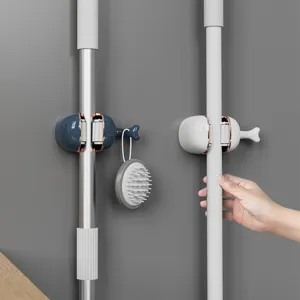 Detailed view of whale-shaped wall-mounted mop holder with secure grip and tail hook utility