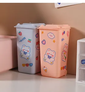 Detail view of pink and blue mini desktop bins with cute cartoon animal stickers.
