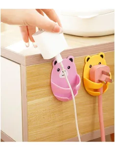 Cute bear-shaped adhesive wall hooks for power plug organization on wooden cabinet side.