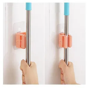 Close-up detail of wall-mounted punch-free mop holder clip with self-adhesive backing