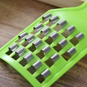 Primer plano de un rallador de repollo manual con cuchillas para rellenos de gyoza