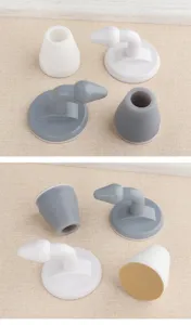 Close-up of white and grey rubber door stoppers with adhesive base detail.