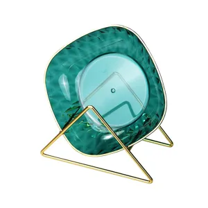 Lujoso plato de aperitivos verde facetado con un elegante soporte de metal dorado