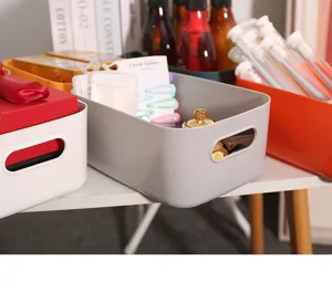 Caja organizadora de escritorio de plástico gris con asas para cosméticos y snacks.