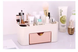 Dettaglio di un organizer minimalista per cosmetici con cassetto rosa e vani per pennelli.