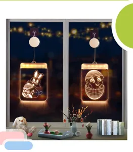 Decoratieve LED Pasen konijn en kuiken hanglampen getoond op een nachtvenster